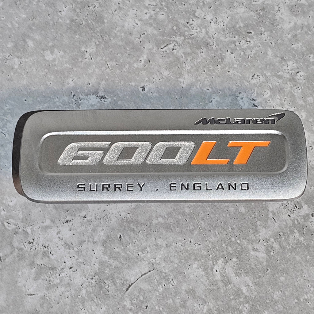 MCLAREN 600LT INTERIOR CENTRE CONSOLE BADGE - SILVER/ ORANGE - 13AB135RP